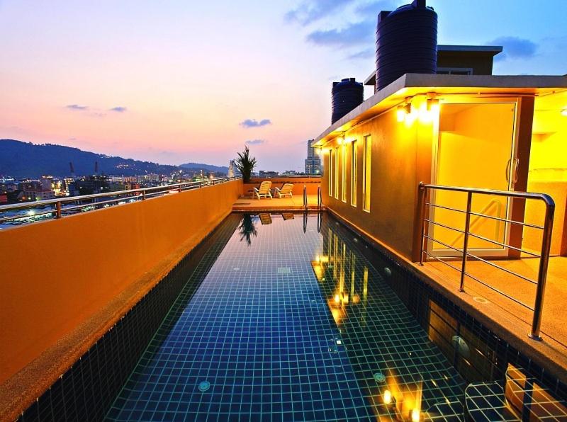 a swimming pool on the side of a building with lights at 88 Hotel in Patong Beach