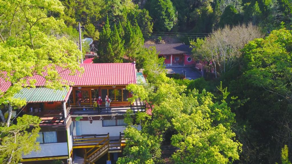 uma casa com um telhado vermelho nas árvores em Hong Wa Cuo南投埔里紅瓦厝山居民宿 em Puli