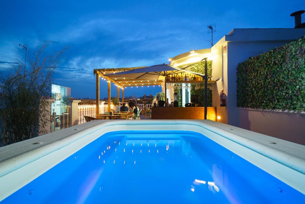 ein Schwimmbad auf dem Dach eines Hauses in der Nacht in der Unterkunft Blanq Carmen Hotel in Valencia