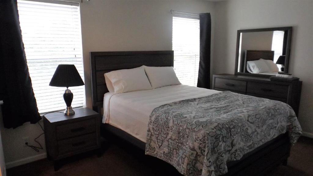 a bedroom with a bed and a dresser and a mirror at Campbell's Accommodations in Gull Lake