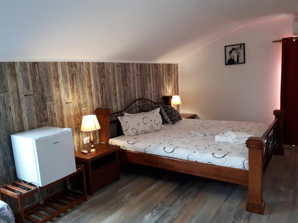a bedroom with a bed with a wooden wall at Casa Mea in Eforie Nord