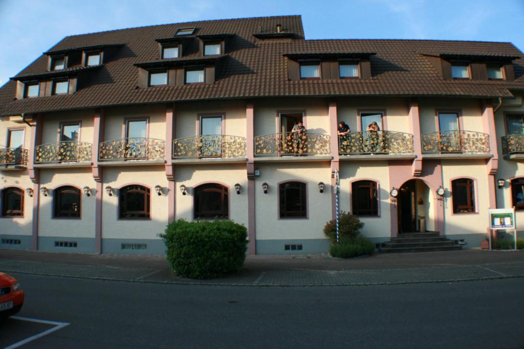 a building with a brown roof and a balcony at Hotel Rebstock in Rust