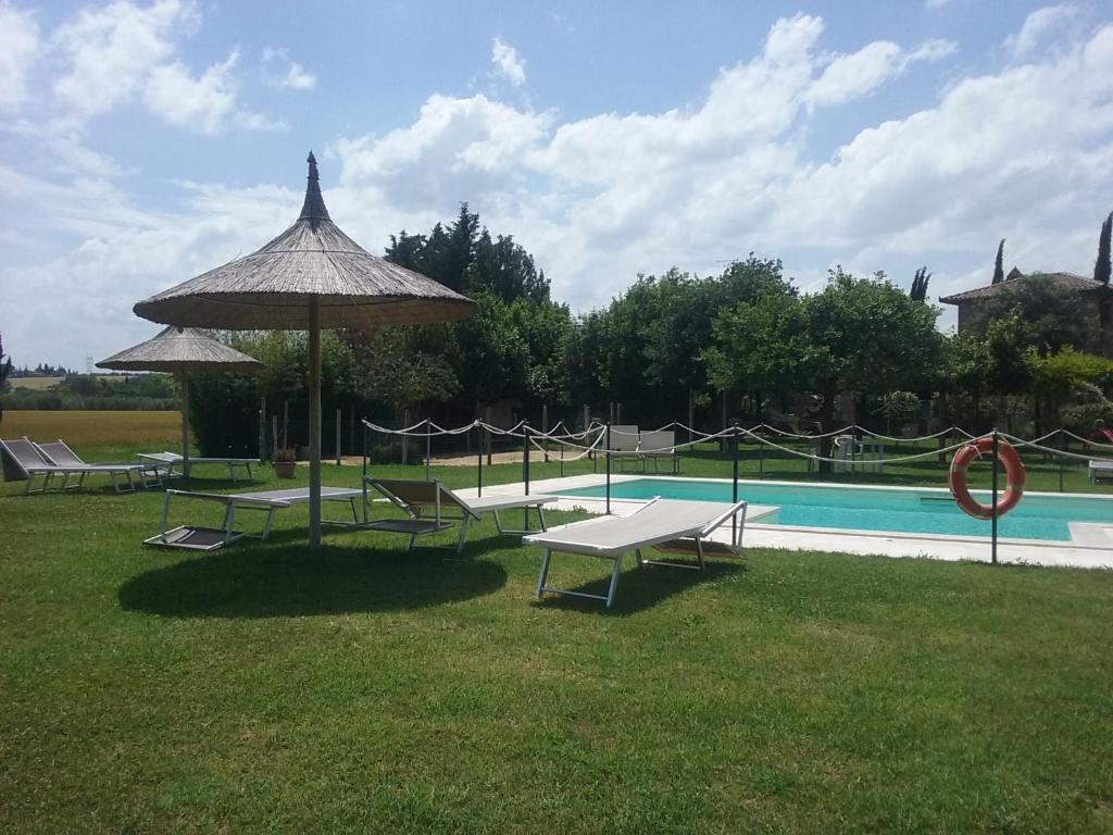 a picnic table and an umbrella next to a pool at Agriturismo Dolce Verde in Castiglione del Lago