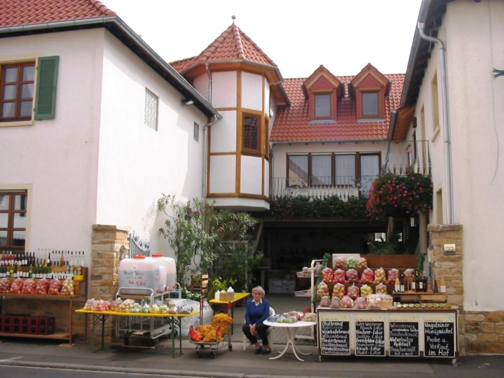 Eine Frau, die vor einem Markt vor einem Haus sitzt. in der Unterkunft Ferienwohnungen Dehn in Bad Dürkheim