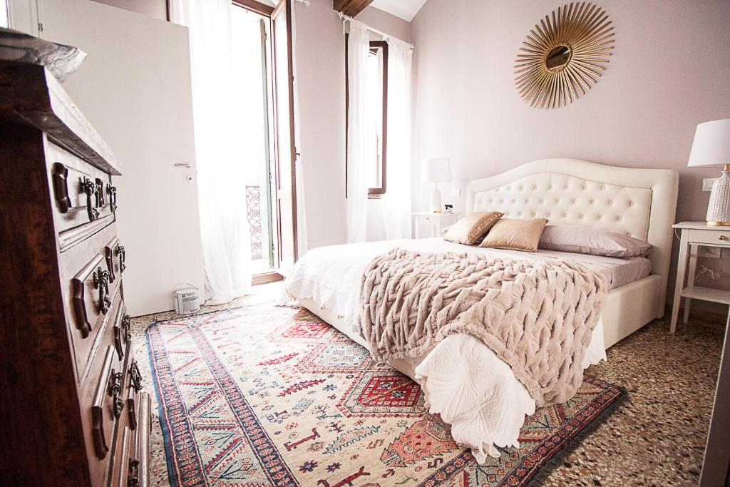 ein Schlafzimmer mit einem großen Bett und einem großen Fenster in der Unterkunft Ca' della scala in Venedig