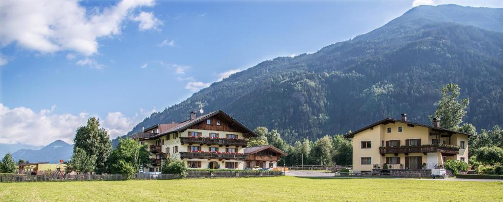 eine Gruppe von Gebäuden vor einem Berg in der Unterkunft Ferienhof Stadlpoint in Ried im Zillertal