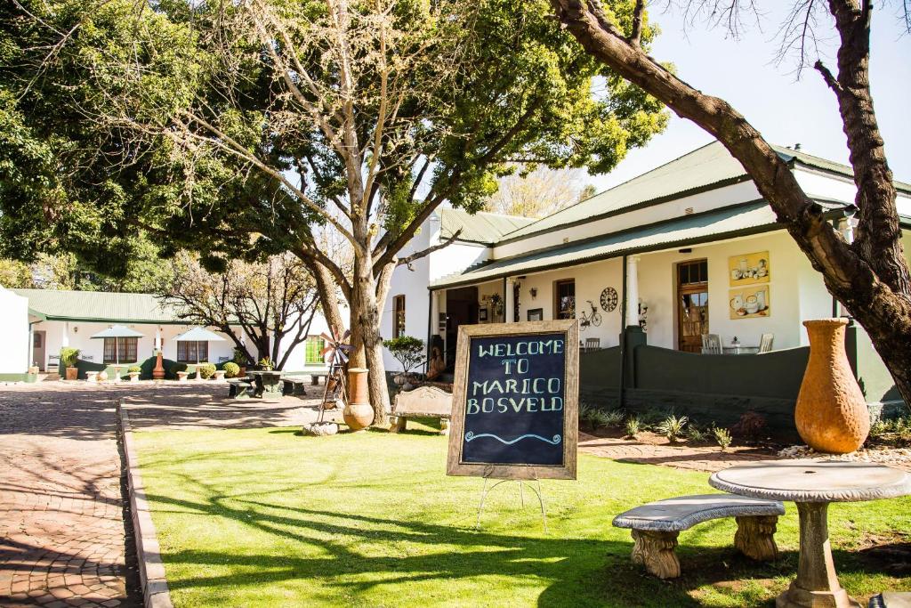 une table de pique-nique et un panneau devant un bâtiment dans l'établissement Marico Bosveld Guesthouse, à Zeerust