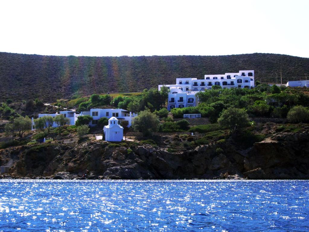 a group of white buildings on a hill next to the water at Patmos Paradise Hotel in Kámbos