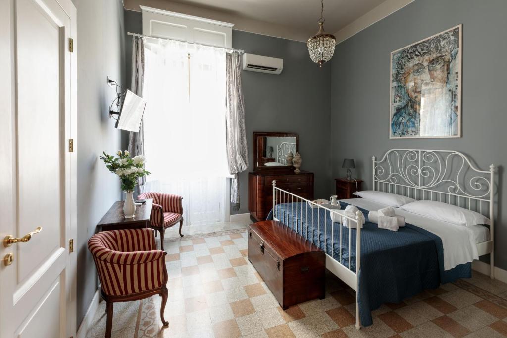 a bedroom with a bed and a table and a window at Talia B&B Guest House in Reggio di Calabria