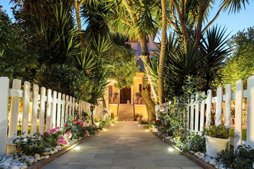 un chemin menant à une maison ornée de palmiers et de lumières dans l'établissement Villa Imperamare, à Santa Maria di Castellabate