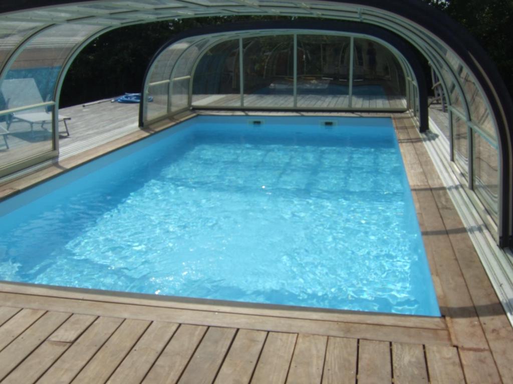 uma piscina com um deque de madeira e uma piscina em Belge ' Attitude Gîte 2 chambres em Commequiers
