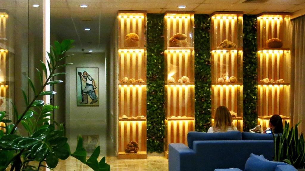 a lobby with a wall of plants with lights at Marina Hotel in Ayia Napa