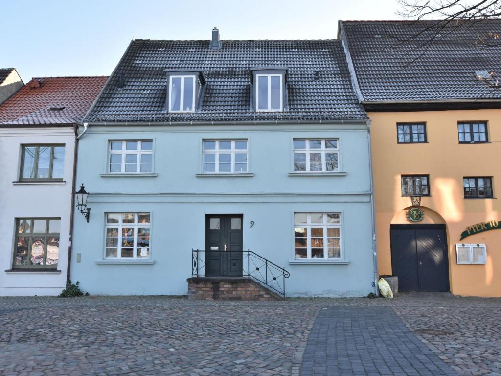 een blauw huis in een geplaveide straat bij Wohnung in Wismar mit Garten in Wismar