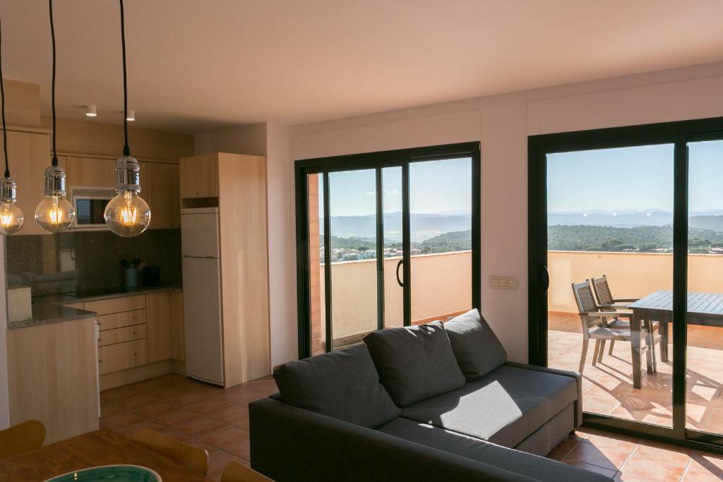 ベグールにある2 bedroom apartment close to the center of Begur. Terrace and panoramic sea views (Ref:H41)のリビングルーム(ソファ付)、キッチン(ガラスの引き戸付)