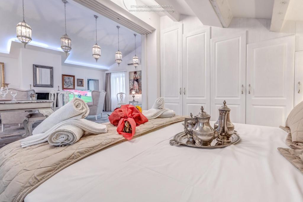 een grote witte kamer met een groot bed en een dienblad. bij Coconella Suite in Corfu-stad
