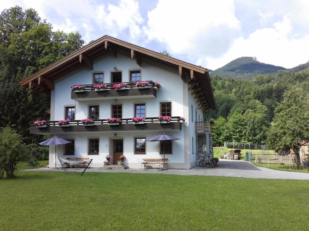 een groot wit huis met bloemen op het balkon bij Ferienwohnungen am Märchenpark in Marquartstein