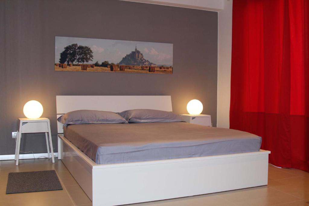 a bedroom with a bed with two lamps on it at Appartamento "Corte Ceci" in Lucca