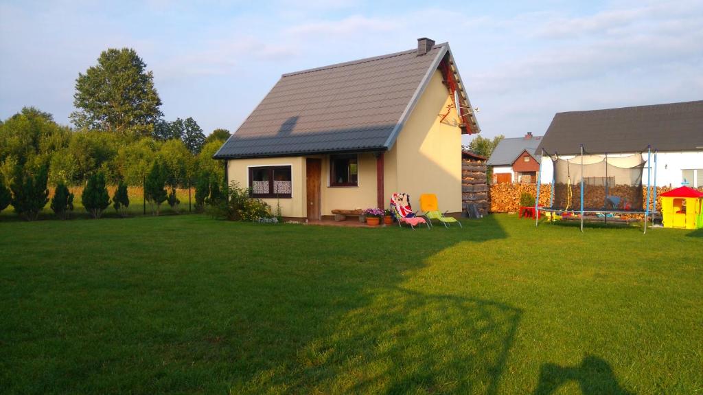 uma pequena casa num quintal com um relvado verde em Domek letniskowy u Anki Leba - Charbrowo em Degendorf