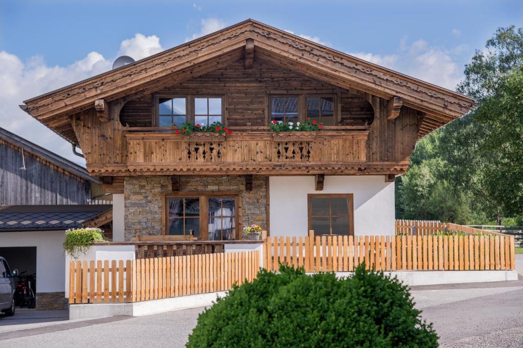 リート・イム・ツィラータールにあるAlpenchalet Stadlpointの木造の家屋で、バルコニーが付いています。