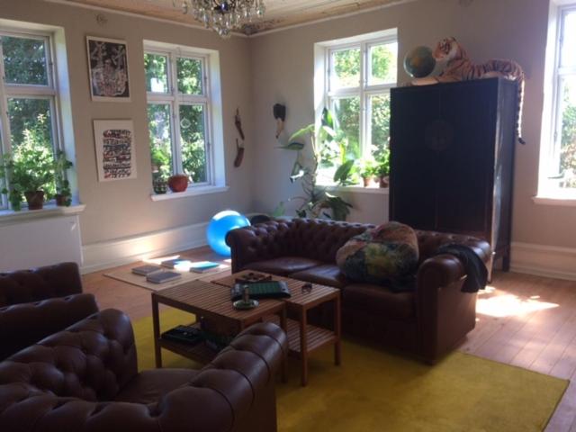 a living room with leather couches and a table at Liebacksgården in Skegrie