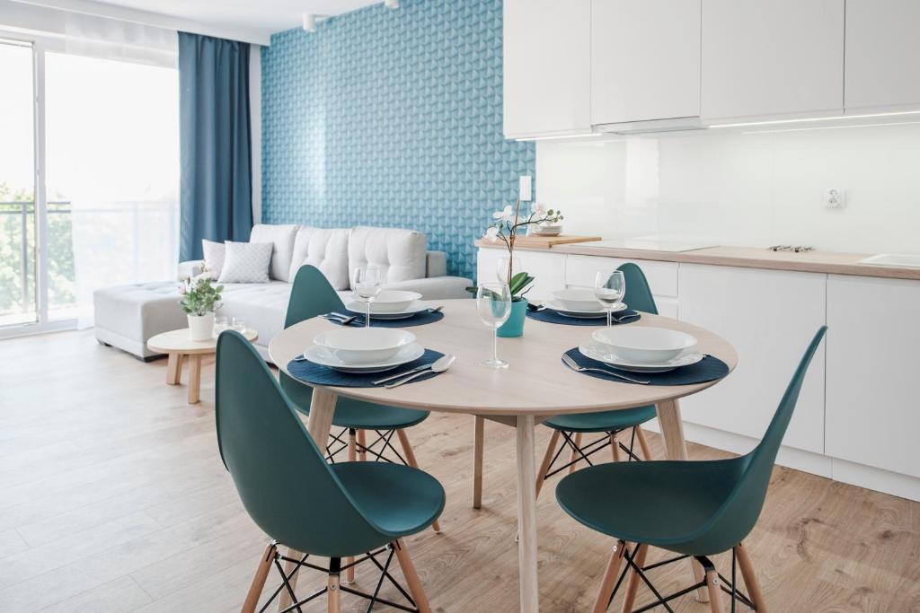グダニスクにあるUnique 3City Apartments - Sea Apartmentのキッチン、リビングルーム(テーブル、椅子付)