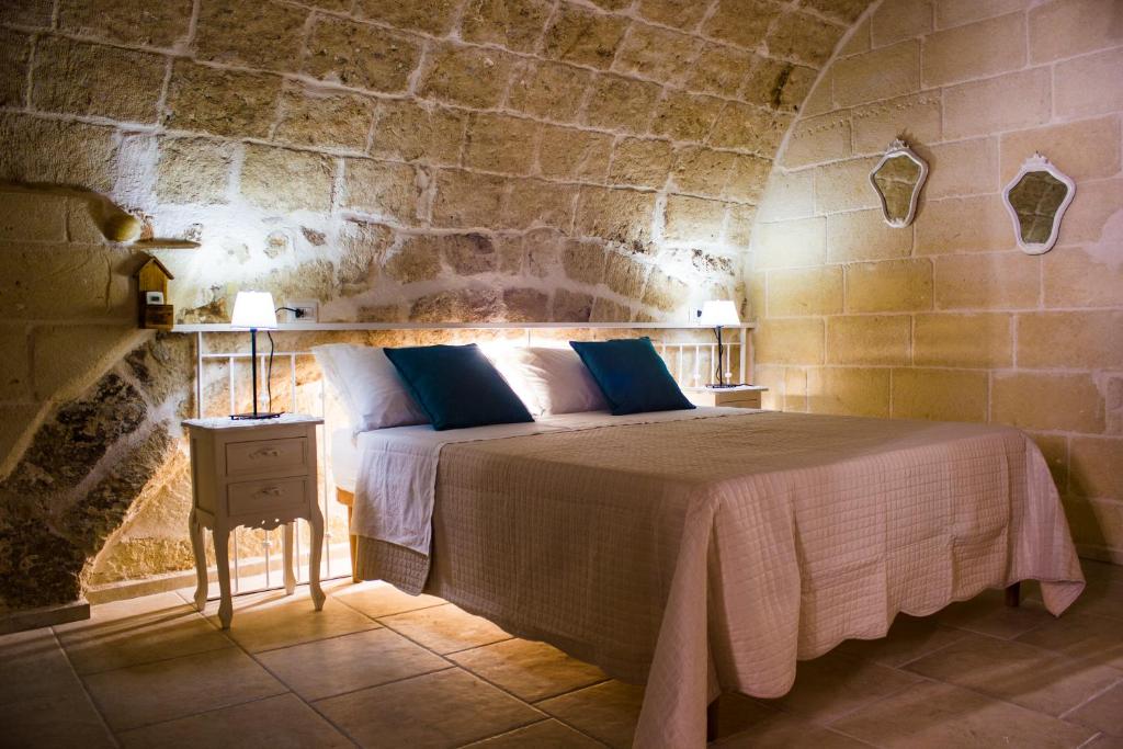 - une chambre avec un lit dans un mur en pierre dans l'établissement Dimora Don Camillo, à Monopoli