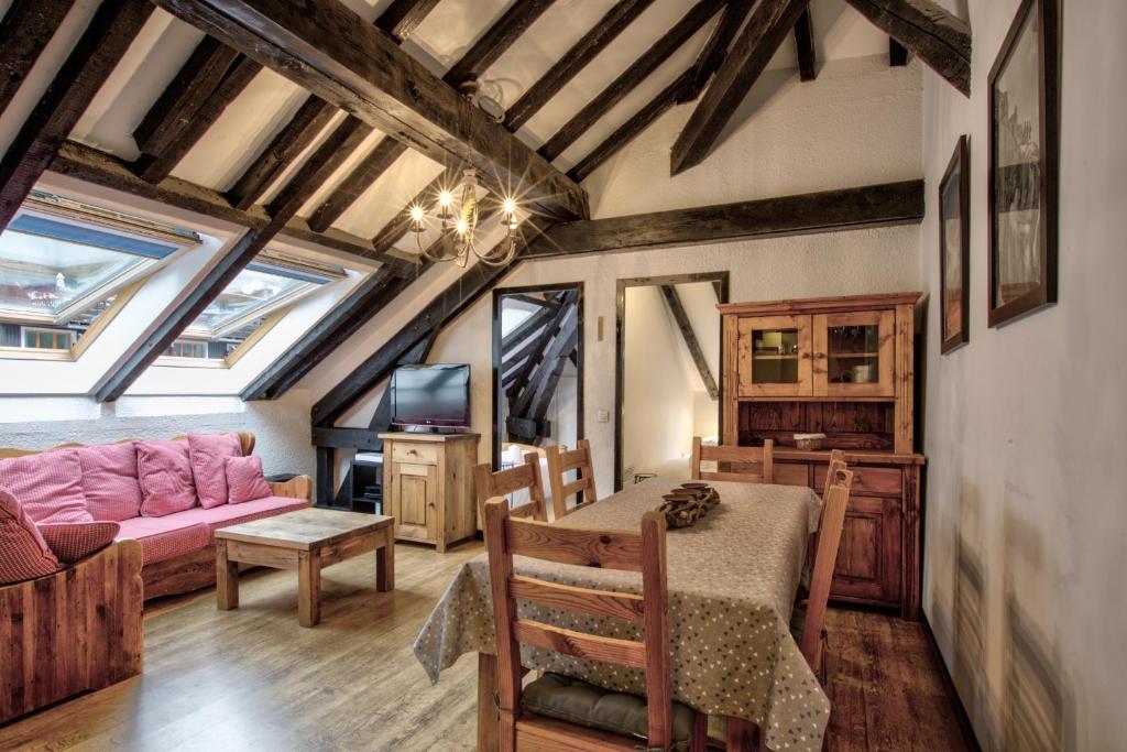 a living room with a table and a pink couch at Apartment Mansard in Chamonix-Mont-Blanc