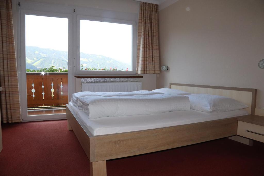 Un dormitorio con una cama y una ventana grande. en Pension Bichlgeiger, en Anras