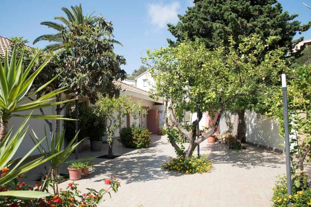 un patio de una casa con árboles y plantas en L'Albero, en Porto Empedocle