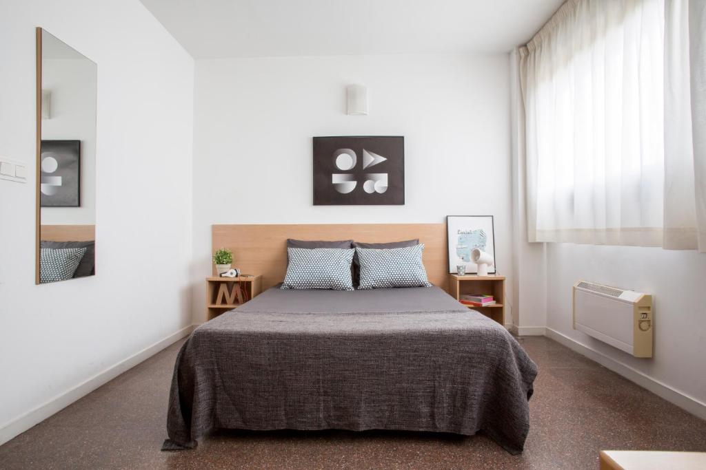 um quarto com uma cama e uma janela em Residencia Universitaria Colegio de Cuenca em Salamanca