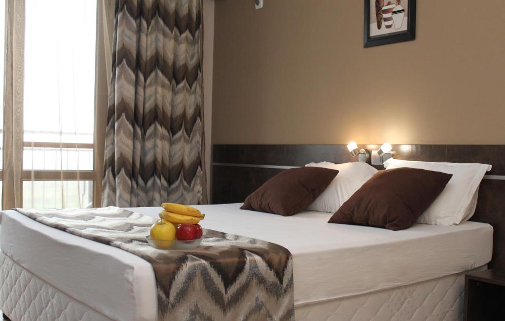 Un dormitorio con una cama con una bandeja de fruta. en Sea & Hill Guest Houses хотелски тип, en Lozenets