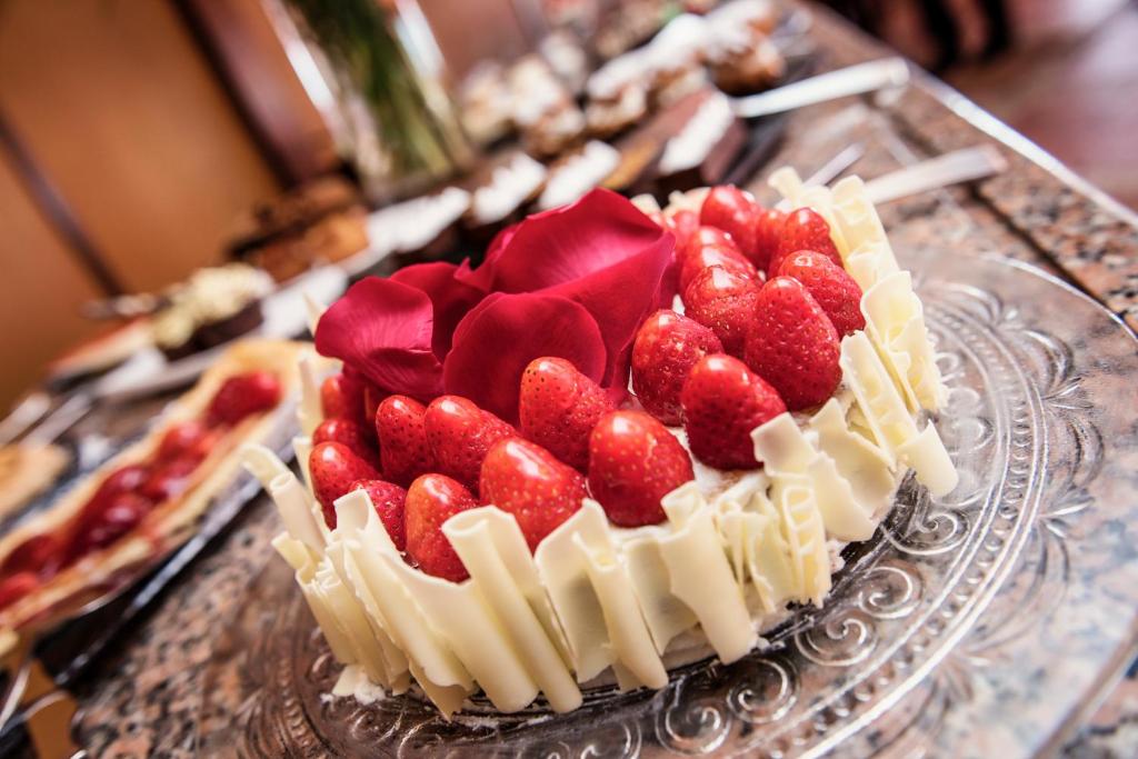 a cake with strawberries on top of it on a table at Rigat Park & Spa Hotel - Adults Recommended in Lloret de Mar