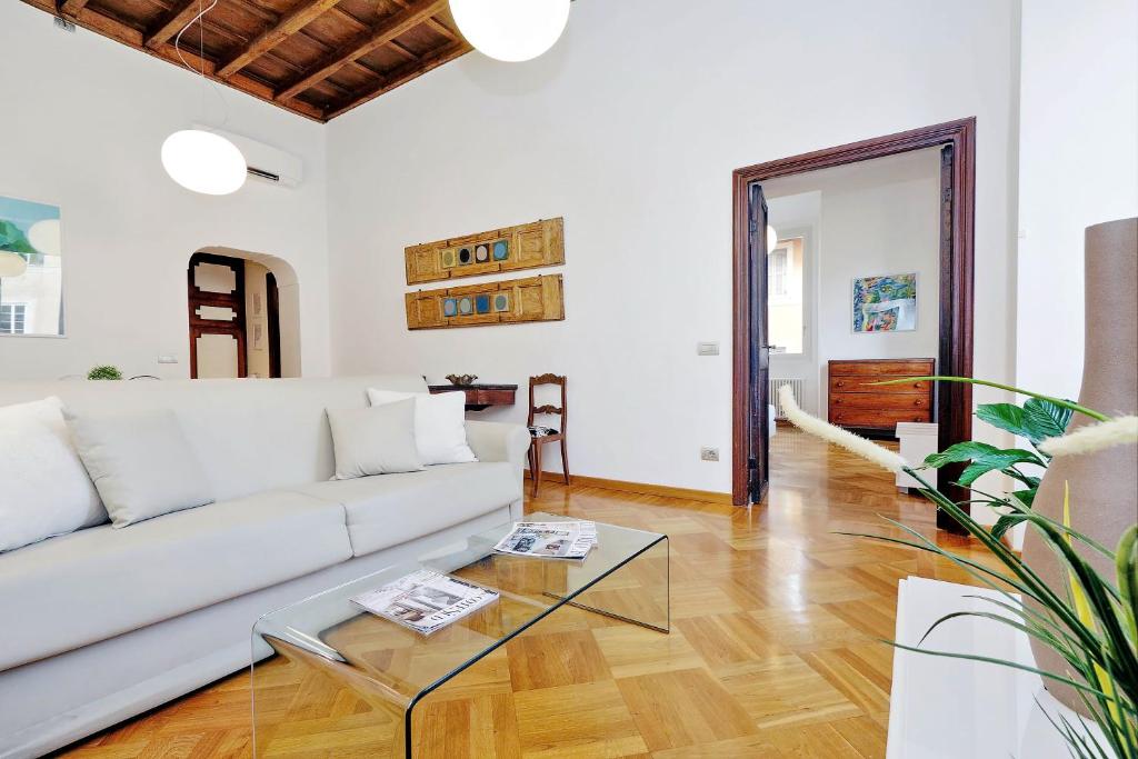 sala de estar con sofá blanco y mesa de cristal en Giulia Charme - My Extra Home, en Roma