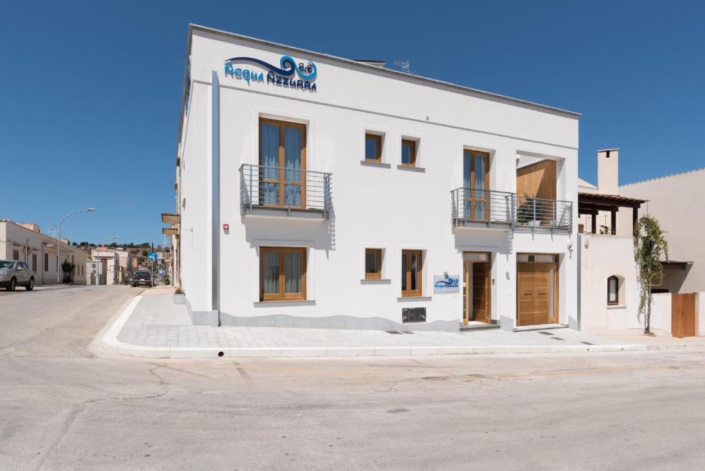 biały budynek po stronie ulicy w obiekcie B&B Acqua Azzurra w mieście San Vito lo Capo