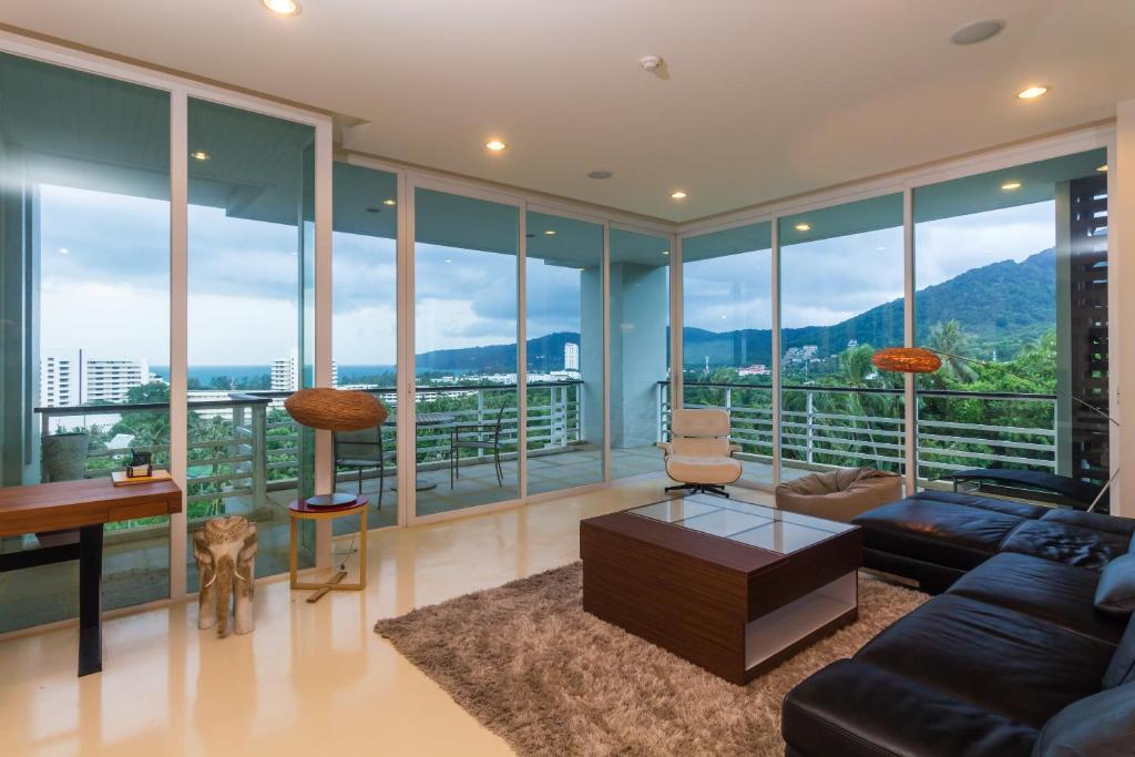 a living room with a couch and a table at The Palm at Veloche Group by Lofty in Karon Beach