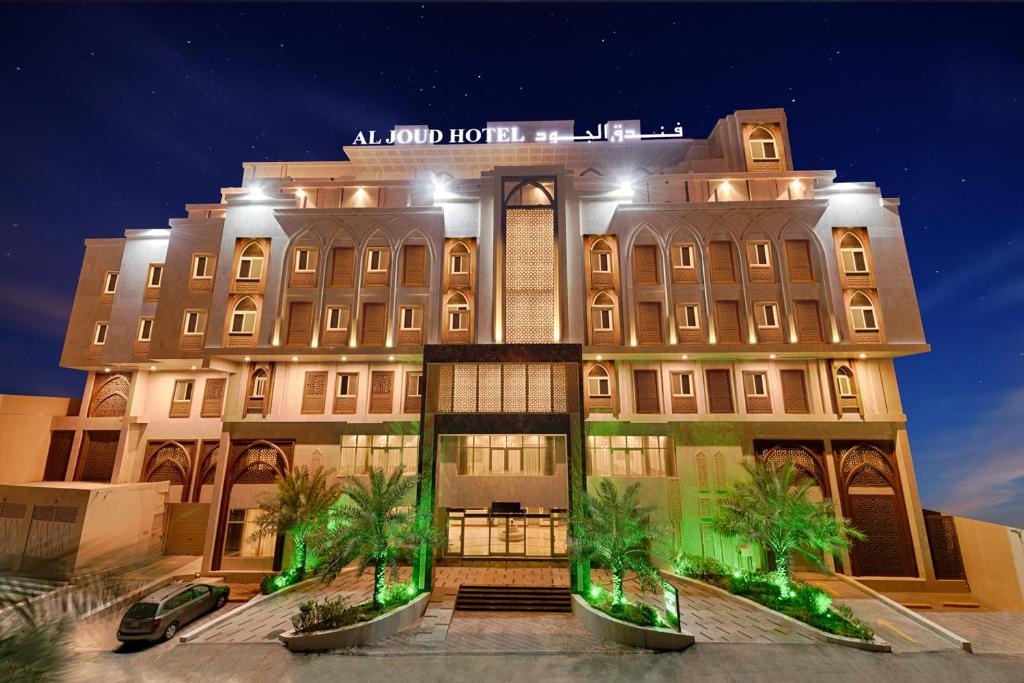 a large building with palm trees in front of it at Al Joud Boutique Hotel, Makkah in Mecca