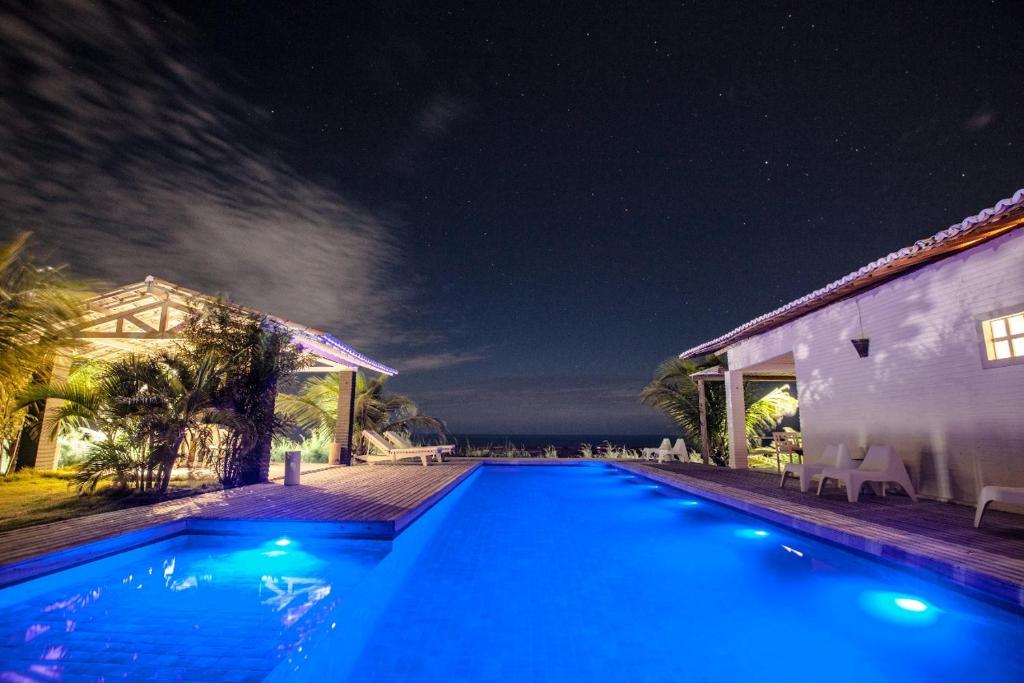 a swimming pool in front of a house at night at Vila Alba in Fortim