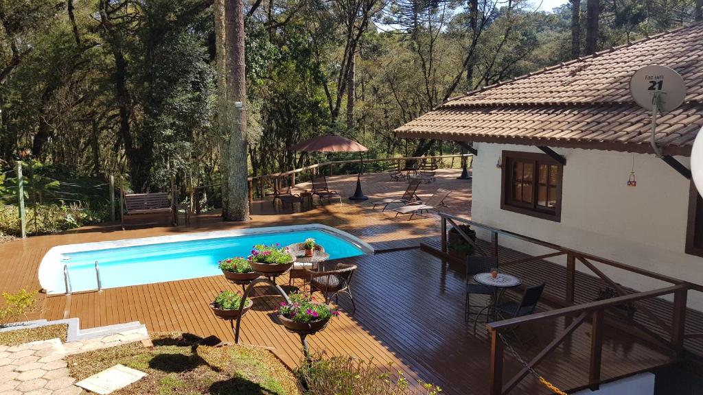 a house with a swimming pool in a yard at Pousada Le Bouquet in Monte Verde