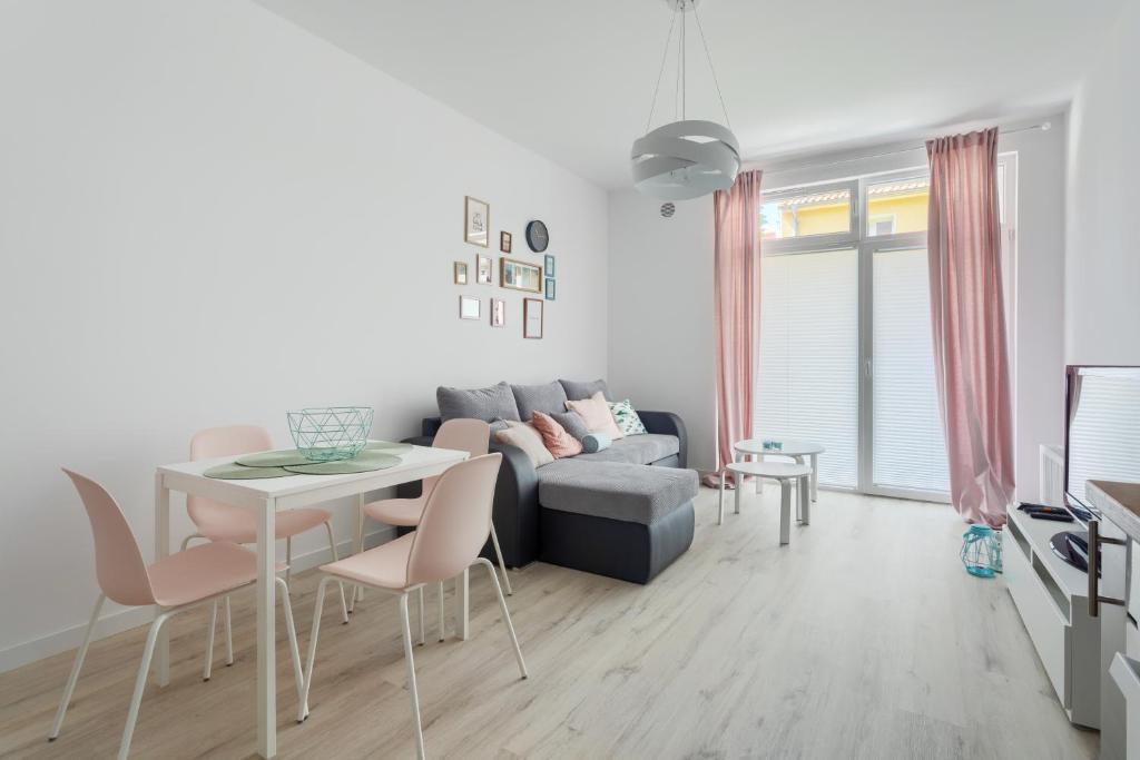a living room with a couch and a table at Apartament Kolorowy Przy Plazy in Giżycko