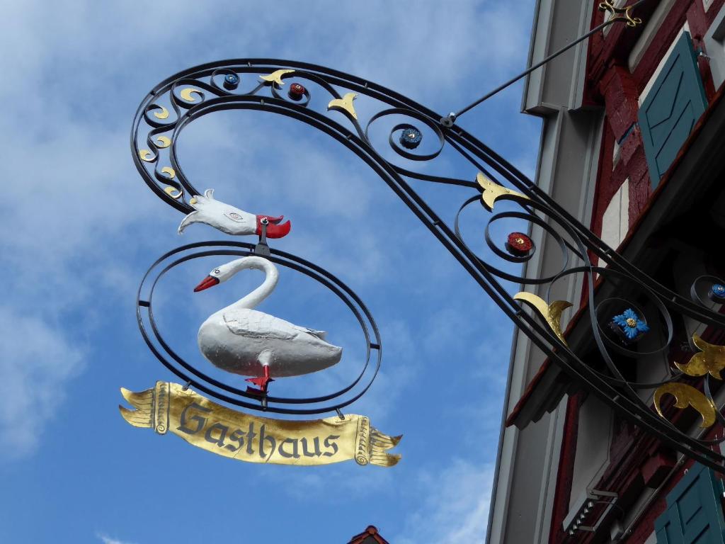 twee zwanen op een bord bevestigd aan een gebouw bij Gasthaus Schwanen in Nehren
