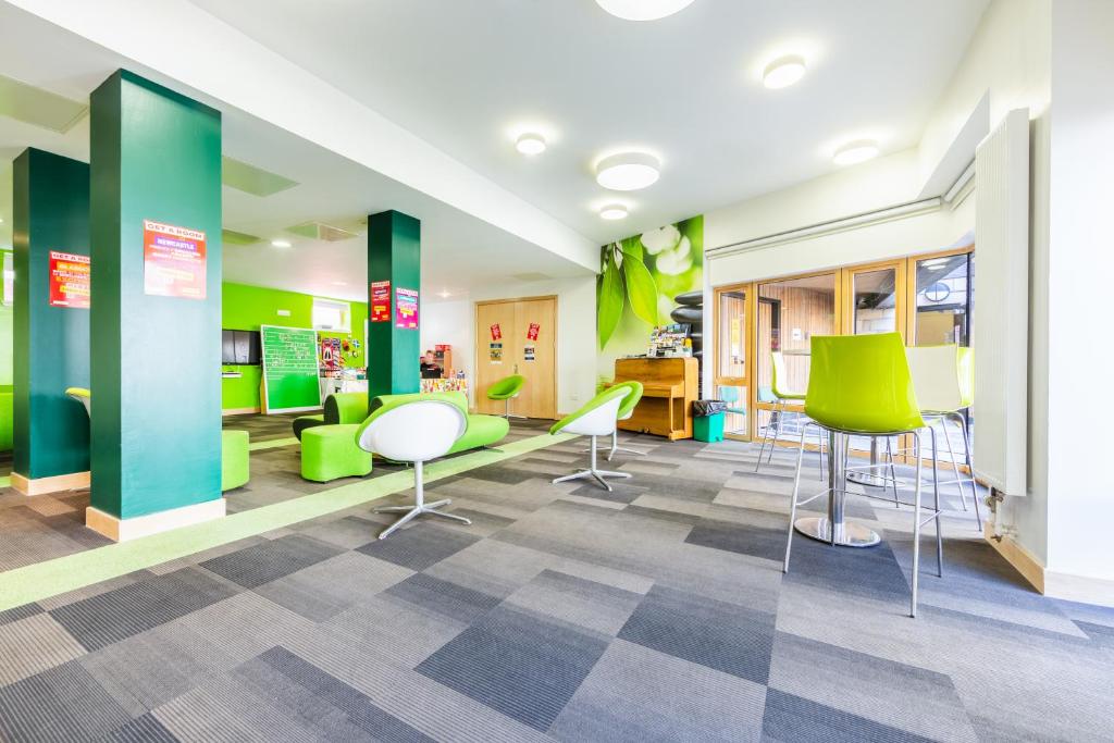 een wachtkamer met groene stoelen en bureaus bij Euro Hostel Edinburgh Halls in Edinburgh