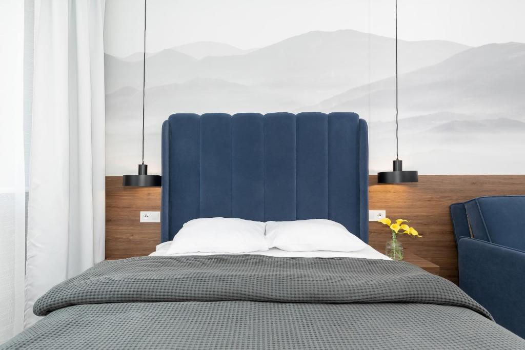 里沃的住宿－Apartament Klifowa z widokiem na morze i basenem，一张带蓝色床头板和蓝色椅子的床