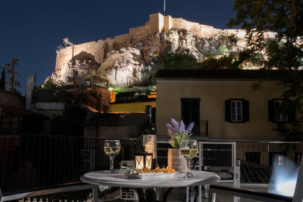 una mesa con copas de vino y un castillo en Acro&Polis, en Atenas