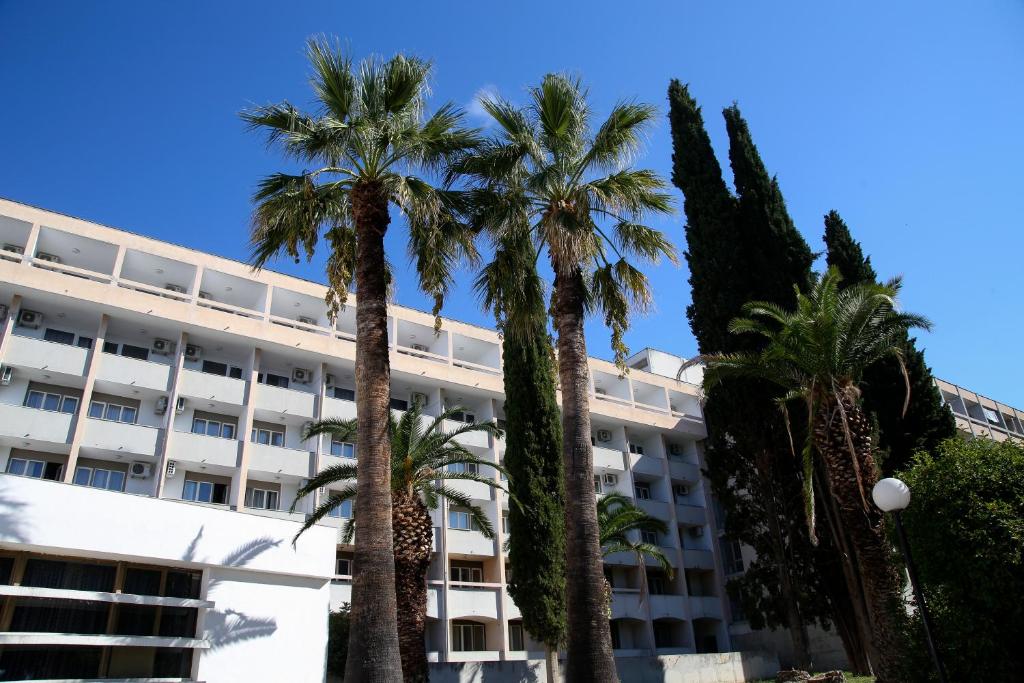 a hotel with palm trees in front of it at Hotel Zagreb in Split