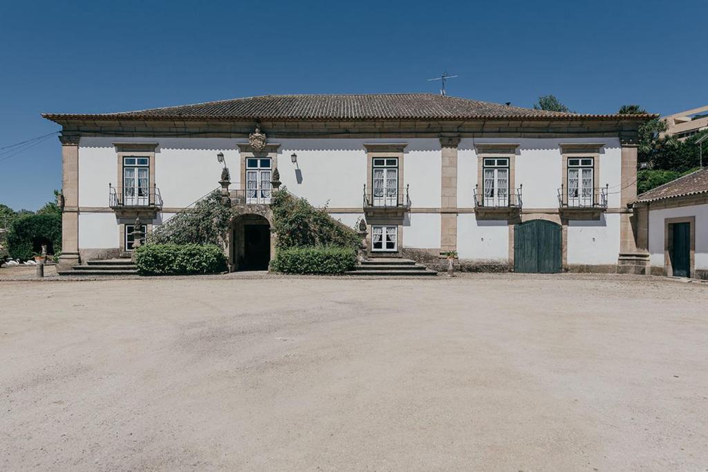 Un grand bâtiment blanc avec de nombreuses fenêtres dans l'établissement Casa Dos Pombais, à Guimarães