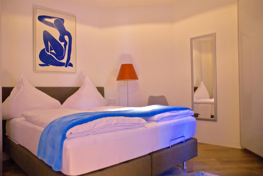 ベルギッシュ・グラートバッハにあるExklusive 2-Zimmer-Wohnung am Schloss Bensbergのベッドルーム1室(青と白のシーツが備わるベッド1台付)