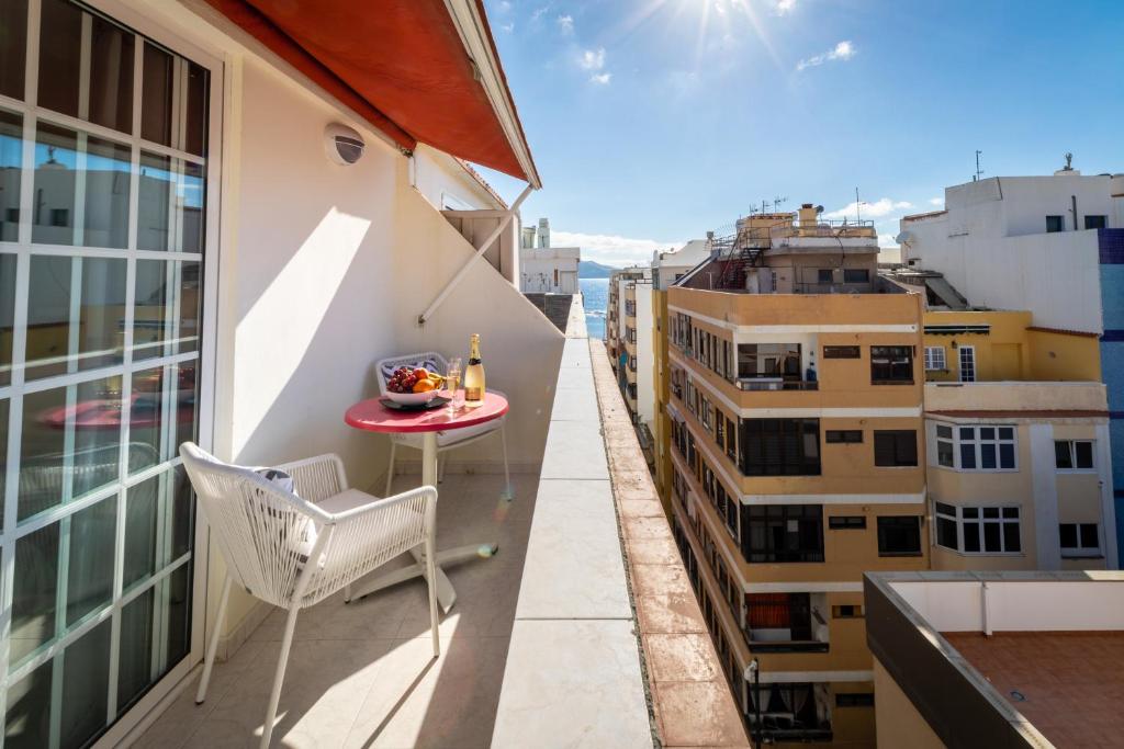 - Balcón con mesa y silla en un edificio en Living Las Canteras Homes - WORKOUT & FREE BIKES, en Las Palmas de Gran Canaria