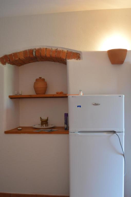 kuchnia z białą lodówką i półką w obiekcie Casa Sarticola w mieście Castelnuovo Magra