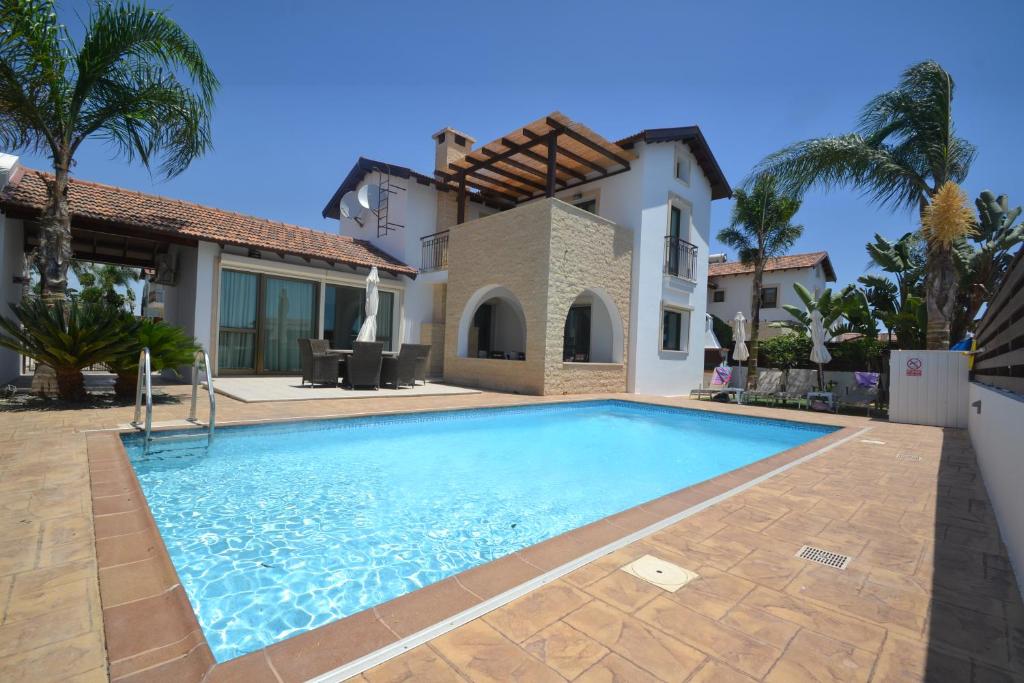 une villa avec une piscine en face d'une maison dans l'établissement Narcissos Villa Thekla, à Ayia Napa