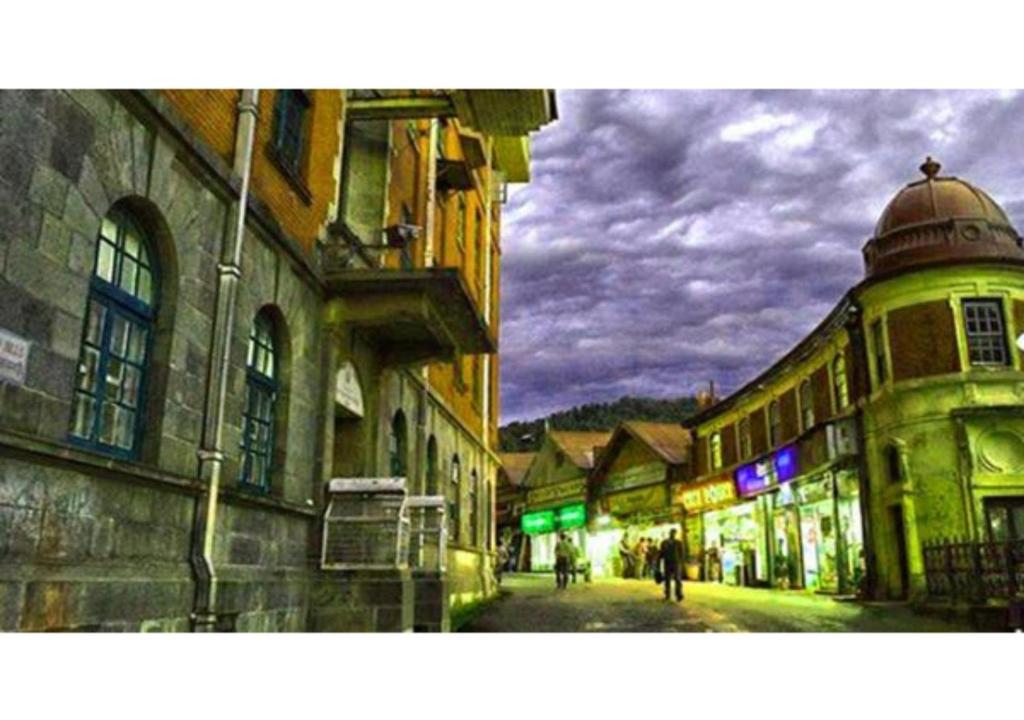 a city street at night with people walking down the street at Shimla Facing Rooms Near Mall Road in Shimla